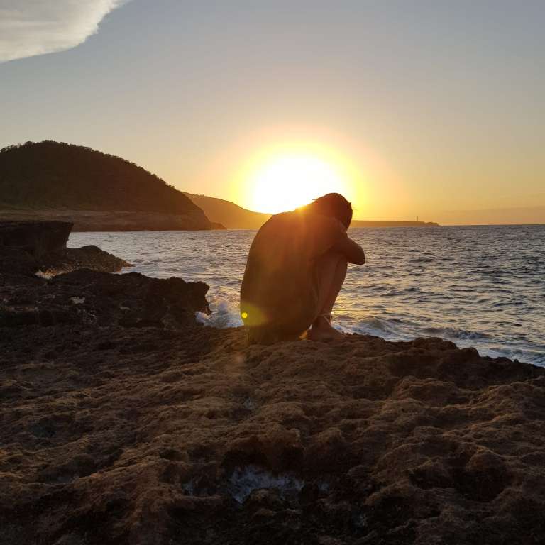 Iemand op de rotsen bij zonsondergang